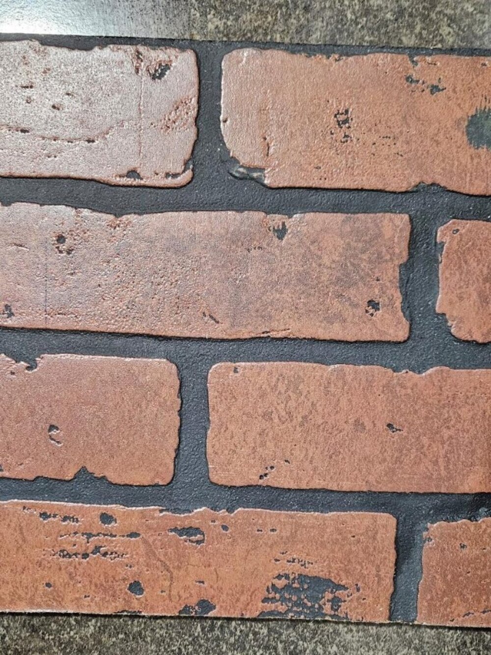 Embossed faux brick wall panel, which provides the appearance of real brick